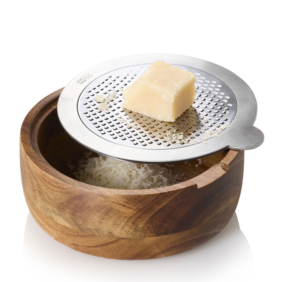 Hartkäse auf einer Reibe über einer Holzschale mit geriebenem Käse.