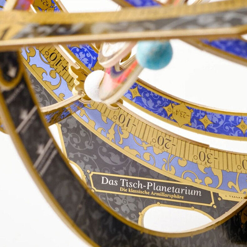 Detail eines klassischen Armillarsphären-Modells mit blauen und goldenen Ziermustern, Beschriftung "Das Tisch-Planetarium".