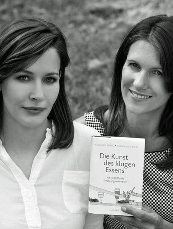 Zwei Frauen, eine hält ein Buch mit Titel "Die Kunst des klugen Essens", die andere ist schwanger.