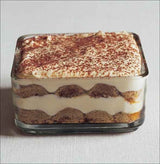 Schichtdessert in einer rechteckigen Glasform mit Cremeschichten und Kakaopulver oben.