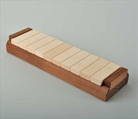 Holzbrett mit acht weißen Dominosteinen auf einer Seite.