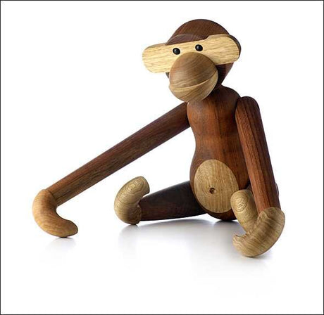Holzfigur eines Affen mit langen Armen, runden Ohren, runden Augen und sitzender Haltung.