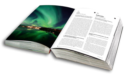 Offenblättriges Buch mit Bild der Nordlichter über Wasser und Landschaft.