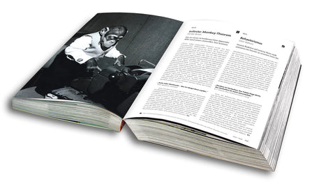 Offenes Buch mit Text und schwar-weißem Foto eines älteren Mannes, der an einem Tisch arbeitet.