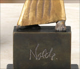 Skulptur eines Tieres mit goldener Kleidung auf einem schwarzen Sockel mit "Nordi" graviert.