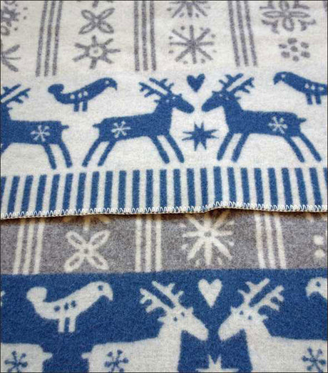 Stoff mit blauen Rentieren, Schneeflocken und Herzmotiven auf weißem Hintergrund.