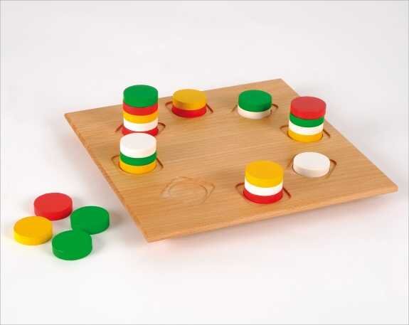 Holzspiel mit bunten, gestapelten Ringen in Rot, Gelb, Grün und Weiß, einige Ringe liegen daneben.