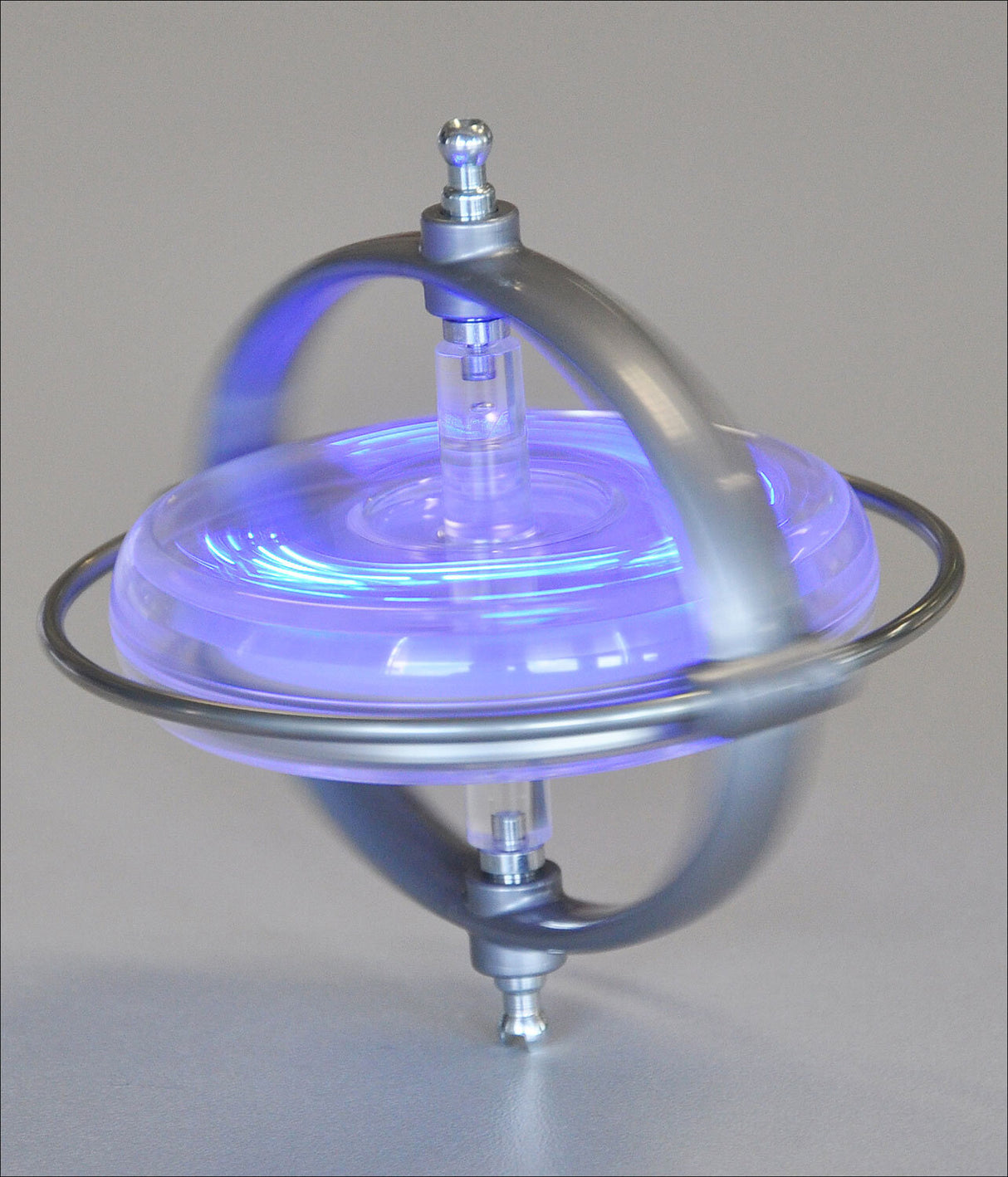 Kleines Gerät mit Metallrahmen, blauer LED-Beleuchtung, auf einer glatten Oberfläche.