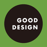 Schwarzer Kreis mit weißen Text "GOOD DESIGN" auf grünem Hintergrund.