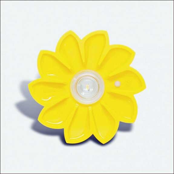Gelbe Blume aus Kunststoff mit zentralem Loch und kleiner seitlicher Öffnung, auf weißem Hintergrund.