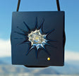 Kleiner, blauer Sonnen- oder Lichtprojektor mit schwarzem Band, auf blauem Himmel.