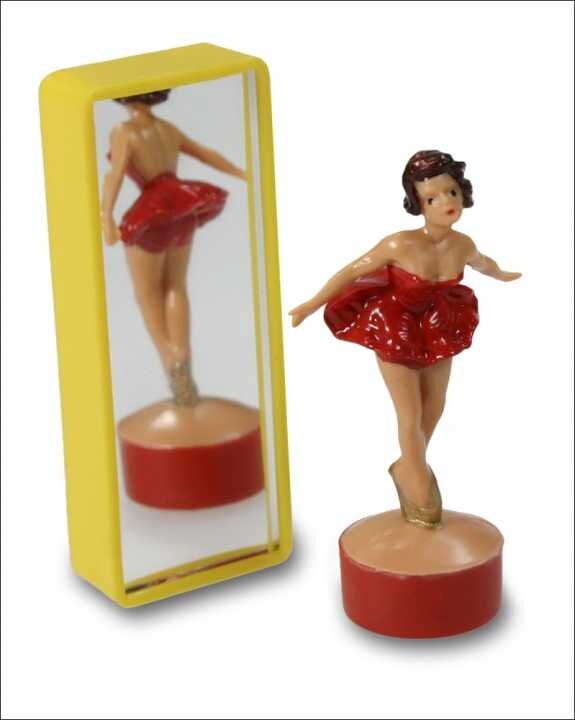 Kleine Ballerina-Figur vor einem Spiegel, trägt rote Tutu, steht auf rotem Sockel.