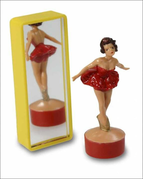 Kleine Ballerina-Figur vor einem Spiegel, trägt rote Tutu, steht auf rotem Sockel.