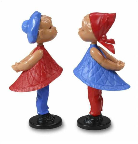 Zwei bunte Figuren, Mädchen mit Kleid, Mütze und Schuhe, stehen sich gegenüber.