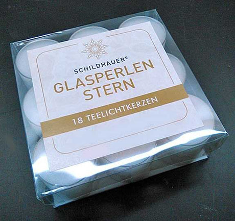 Schachtel mit 18 Teelichtkerzen in Glasperlen-Stern-Form, transparent.