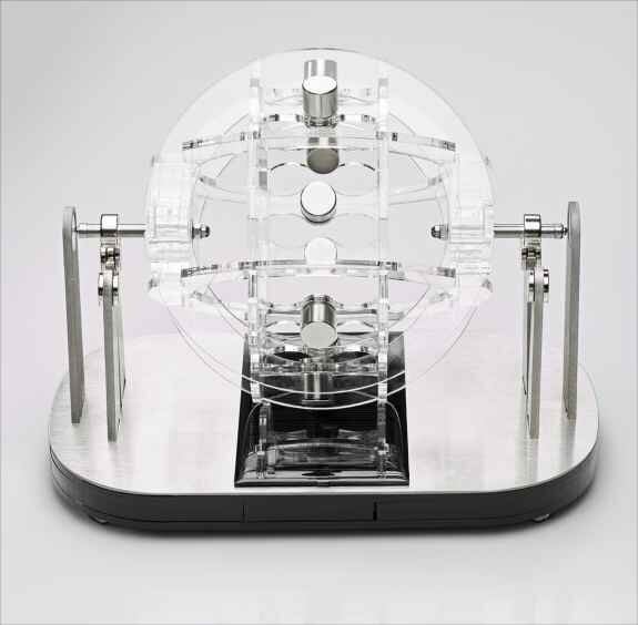 Präzises mechanisches Modell mit transparenten und metallischen Komponenten auf schwarzem Basis.