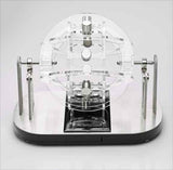 Präzises mechanisches Modell mit transparenten und metallischen Komponenten auf schwarzem Basis.