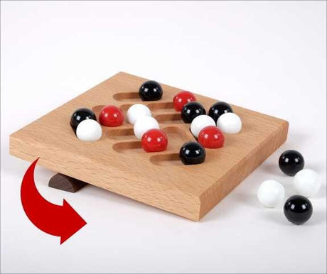 Holzbrett mit schwarzen, weißen und roten Kugeln, die in Schlitze verschoben werden.