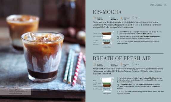 Ein Glas Eiskaffee mit Milch, Eiswürfeln und Schokoladensirup, daneben bunte Strohhalme auf einem grauen Untergrund.