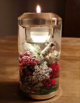 Vaseline mit Wasser, Weihnachtsdeko, Schneeflocke, Beeren, Tannenzapfen, brennende Kerze.