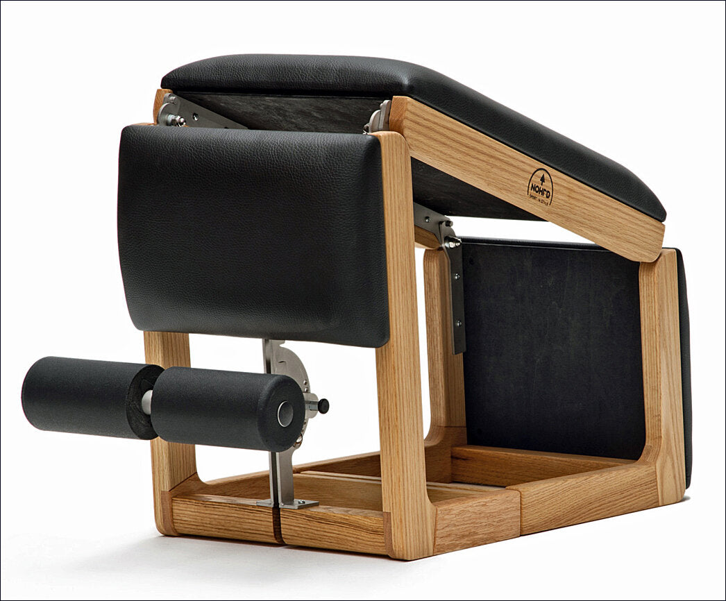 Pilates-Reformer mit Holzrahmen, Polsterung und Rollen.