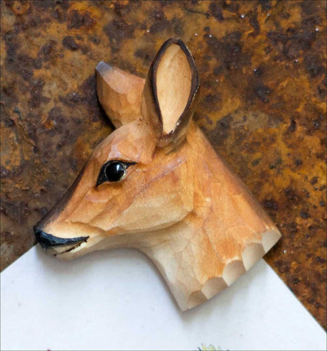 Papiermodell eines Rehkopfes mit Ohr, Auge, Schnauze und Zähnen auf braunem Untergrund.