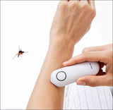 Person benutzt ein elektrisches Insektenstich-Entfernungsgerät am Arm, neben einer fliegenden Biene.