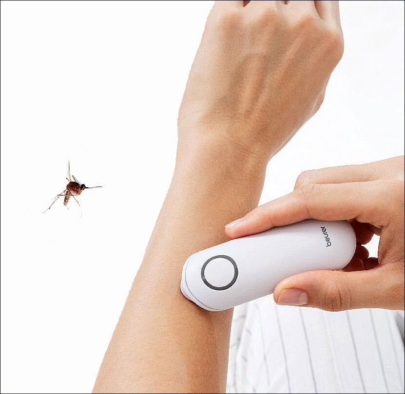 Hand hält elektrischen Insektenvernichter an Unterarm, Insekt fliegt in Richtung Gerät.