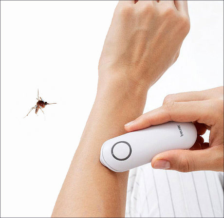 Hand hält elektrischen Insektenvernichter an Unterarm, Insekt fliegt in Richtung Gerät.