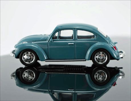Kleiner, blauer Modellauto eines VW Käfer, mit Spiegelung auf schwarzem Untergrund.