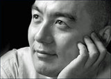 Schwarz-weißes Portrait eines Mannes, der nachdenklich zur Seite schaut, mit Hand an seinem Gesicht.