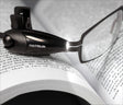 Brille mit integriertem Licht auf einem offenen Buch mit Text.
