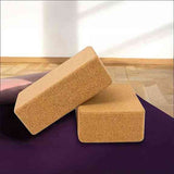 Zwei Yoga-Blöcke aus Kork auf einer Yogamatte vor einem hellen Hintergrund.