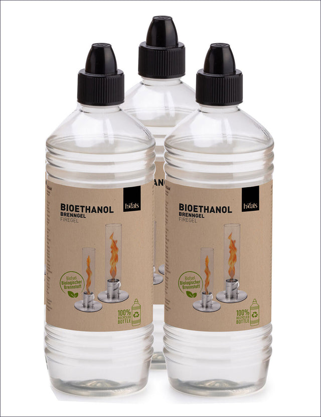 Drei transparente Flaschen mit Bioethanol, mit schwarzen Tropfenzylindern und Etiketten.