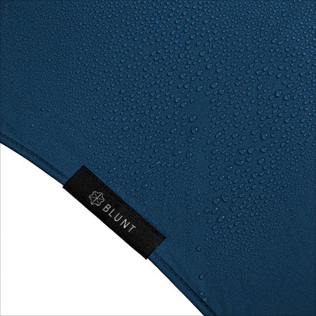 Blaue wasserdichte Textilfläche mit Wassertröpfchen, schwarzes Label mit "BLUNT" und einem Sternsymbol.