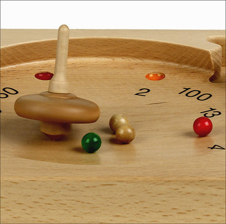 Holzspiel mit bunten Kugeln und einer drehbaren Scheibe auf einer runden, flachen Holzfläche.