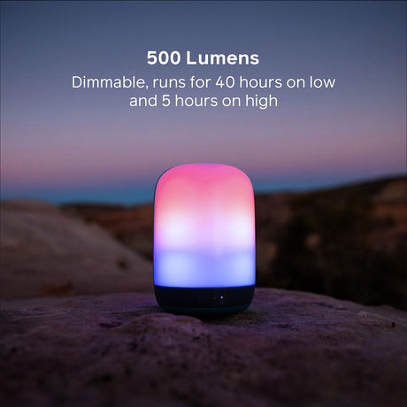 Smartphone mit farbigem, dimmbarem Licht, auf Felsen bei Sonnenuntergang.