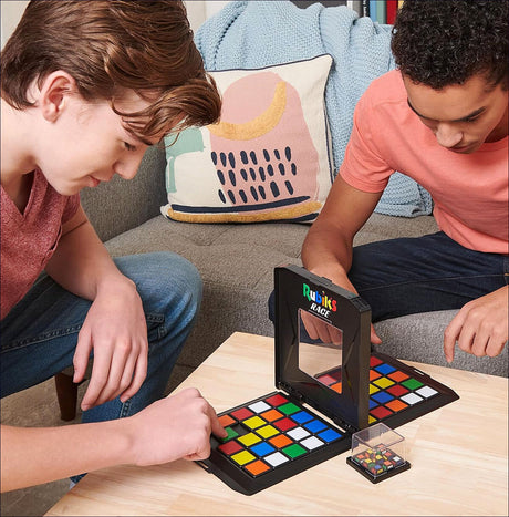 Zwei junge Männer spielen mit einem Rubik's Cube Race Spiel auf einem Tisch.