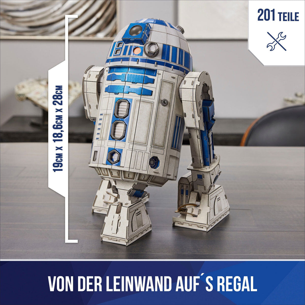 Papiermodell des Star-Wars-R2-D2, 28 cm hoch, 19 cm breit, 18,6 cm tief, auf einem Tisch.