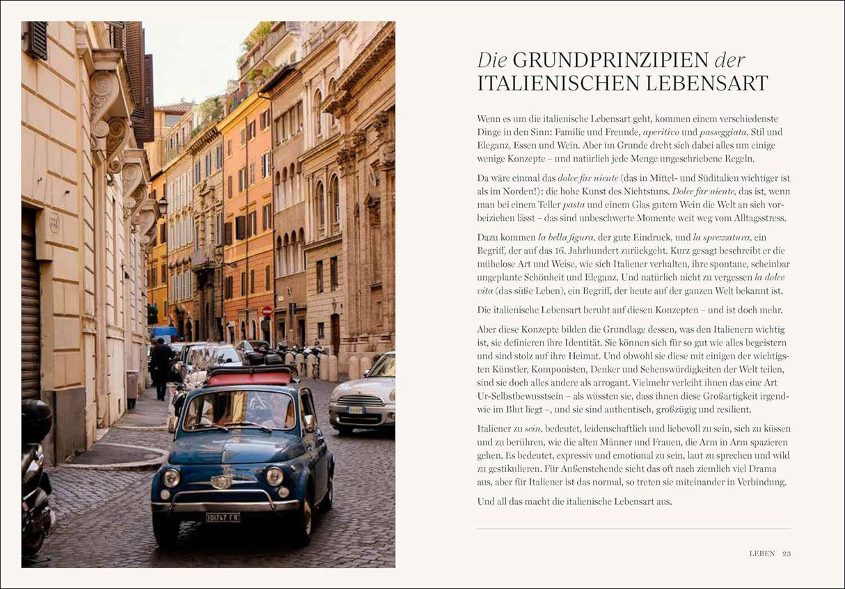 Blick auf eine enge, gepflasterte italienische Straße mit alten Gebäuden und einem blauen Fiat 500.