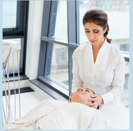 Ärztin führt eine Gesichtsmassage bei Patientin im Krankenhaus durch.