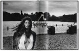 Schwarz-weißes Bild eines Frauenporträts vor einem Wassersee mit Spielplatz im Hintergrund.