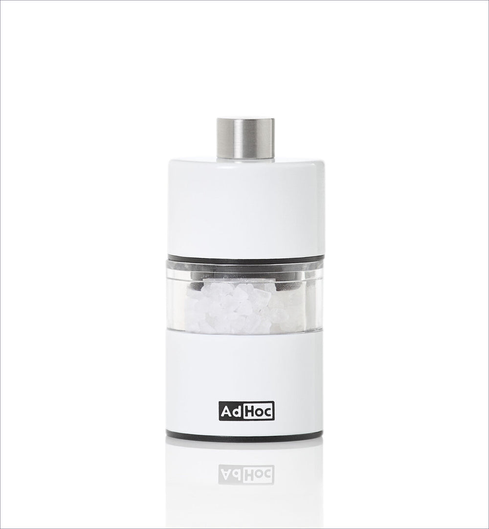 Weiße Salz- oder Pfeffermühle mit silbernem Deckel und transparentem Mittelteil, auf weißem Hintergrund.