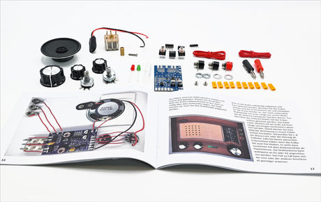 Elektronikbauteile, Lautsprecher, Kabel, Platine, LEDs, Widerstände, Schrauben, Anleitung auf offener Zeitschrift.