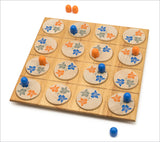Brettspiel mit runden Holzscheiben, blauen und orangefarbenen Spielfiguren, auf weißem Hintergrund.
