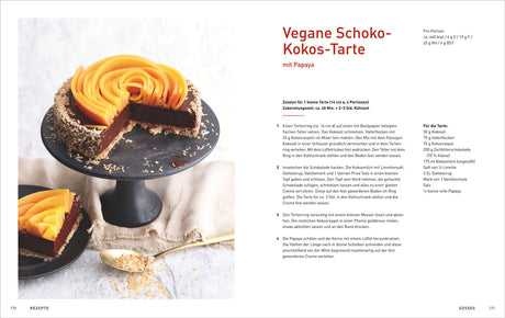 Vegane Schoko-Kokos-Tarte mit Papaya, auf schwarzem Tortenständer, daneben ein Stück auf einem schwarzen Teller.