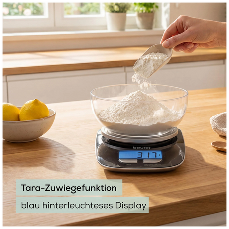 Beurer KS 25 Küchenwaage LE 2026 beim Zuwiegen von Mehl mit blau beleuchtetem Display und Hinweis zur Tara-Funktion
