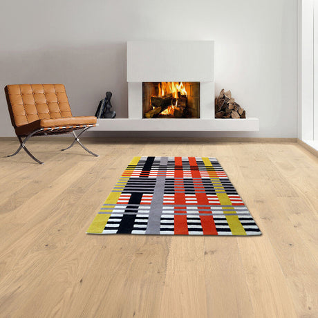 Moderner Raum mit Kamin, braunem Sessel, buntem geometrischem Teppich und Holzfußboden.