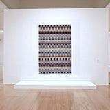 Hängendes Wandbild mit geometrischem Muster aus bunten Quadraten in einem Museum.