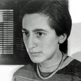 Schwarz-weißes Portrait einer Frau mit kurzen dunklen Haaren, Blick nach rechts, trägt einen Pullover und eine Halskette.